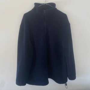Mörkblå fleece - Mörkblå fleece utan märke och saknar också storlek. Skulle uppskatta denna till runt en vanlig M för herr, men funkar givetvis även unisex! Endast använd ett fåtal gånger.