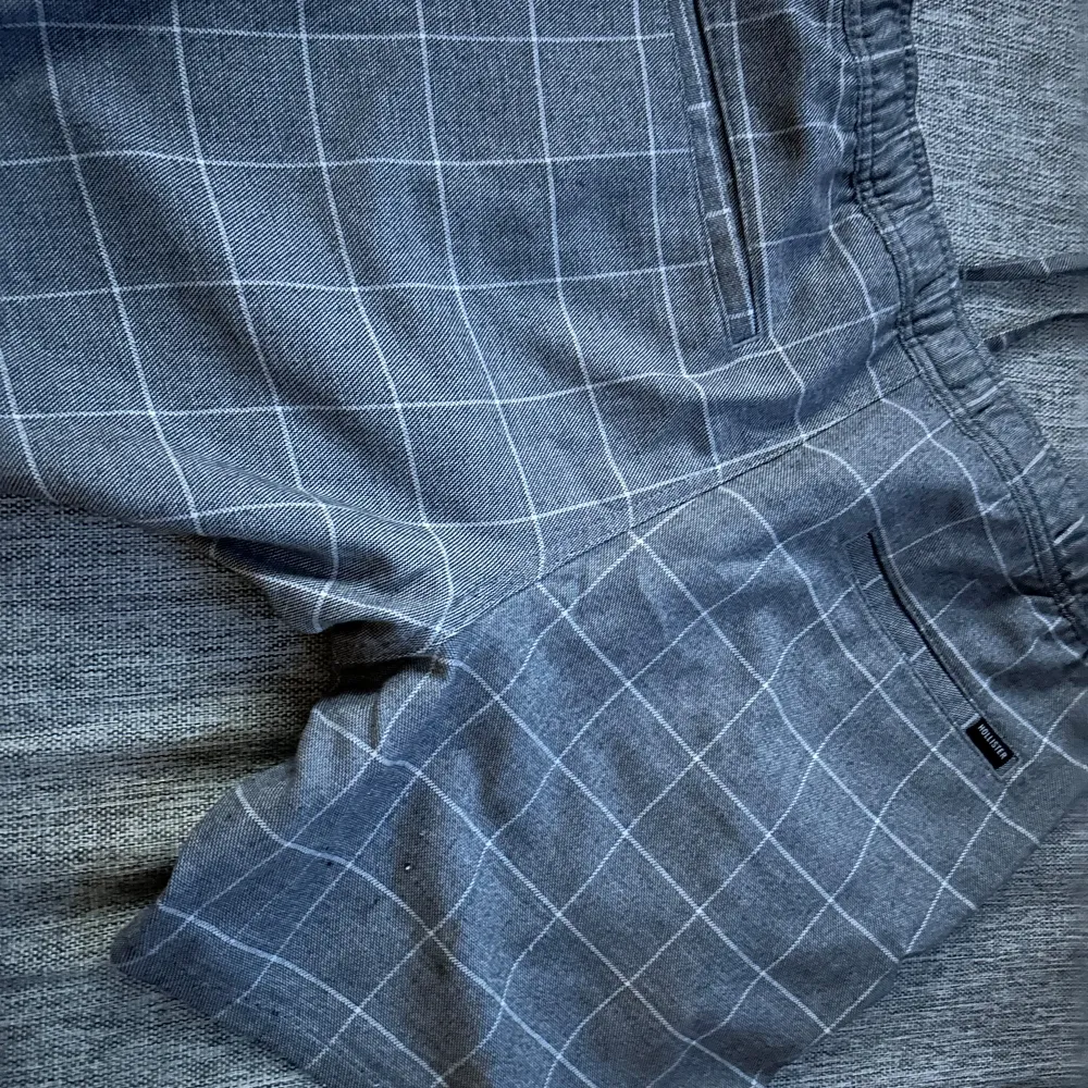 Ett par gråa shorts från Hollister med ett vitt rutmönster. Shortsen har en elastisk midja och är  i ett bekvämt material. HÖGST BUD FÅR DEN . Shorts.