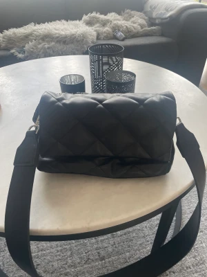 Väska - Säljer denna väska från åhlens med ett extra påtaget axelband från åhlens. 