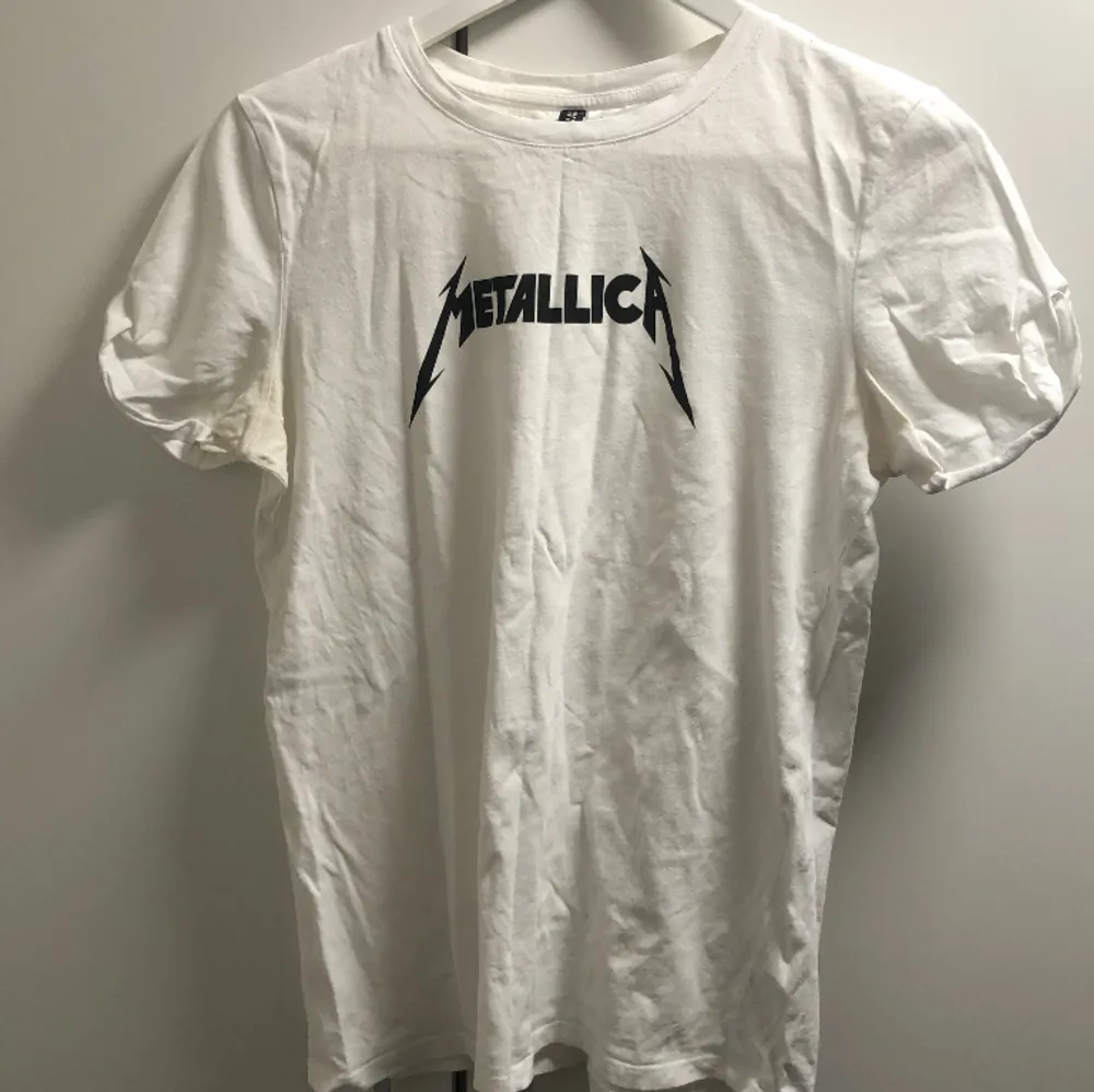 En vit tshirt med metallica loggan framme. T-shirts.