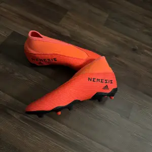 Orangea/röda fotbollsskor från Adidas i storlek 36 och två tredjedelar. Helt oanvända och i mycket bra skick!