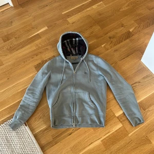 Burberry zip hoodie - Säljer ni denna väldigt sällsynta burberry zip hoodie för den har blivit för liten för mig. Tröjan har inga skador eller inga fläckar.  Storlek S  Skriv gärna om ni har frågor. Priset är inte hugget i sten vid snabb affär MVH Victor