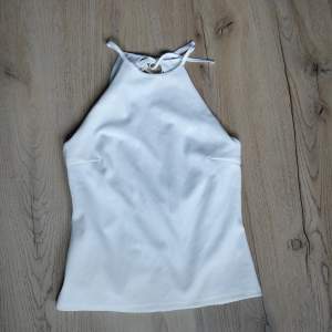 Fint vitt linne som är köpt på Sellpy men som ursprungligen är från h&m. Kan justeras med knytning i nacken och har öppen rygg. Fint skick och säljer då det inte kom till användning