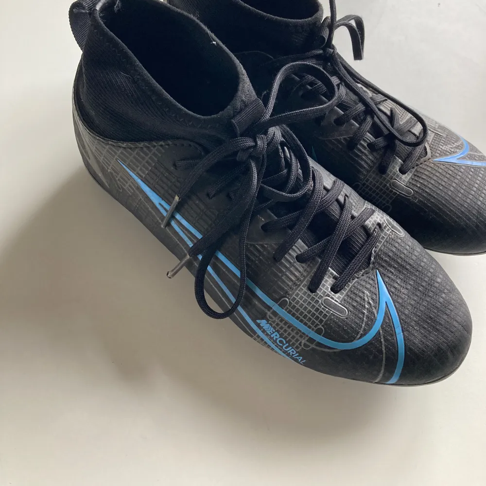 Blå svarta Nike fotbollsskor för gräs och konstgräs. Storlek 35 och väldigt bra skick. Skor.