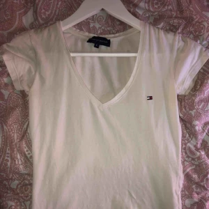  - En v-ringad Tommy hilfiger t-shirt, använd men i bra skick! Kan fraktas men köparen står för frakten!