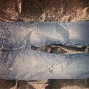  - Ljusblå jeans från HOLLISTER med slitningar i strl W25 L31. 