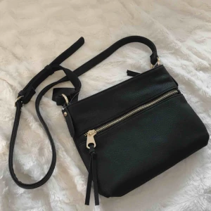  - Helt oanvänd axelremsväska från Åhléns egna märke med gulddetaljer. Prislappen är kvar! Bandet går att justera till önskad längd. Nypris: 249. 🌹 Frakt tillkommer! 