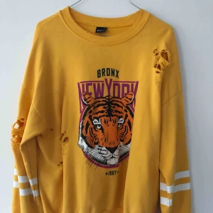  - Gul tröja med revor i. Tre små fläckar finns på tröjan men annars fin!