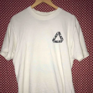  - T shirt från det brittiska skatemärket Palace. Tröjan är vit med klassisk ”tri-logo” i mariblå på både bak- och framsidan av plagget.  Nyskick 10/10 condition. Kontakta mig om ni har frågor eller vill se mer bilder. 