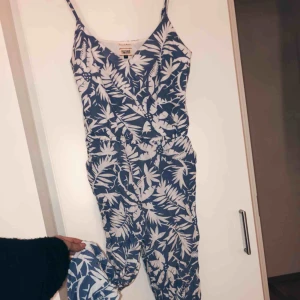  - Byxdress, äkta från Tommy Hilfiger. Storlek XS. Säljer på grund av för liten. Fint skick, ljusblå med vitt blommönster. 