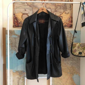  - Svart skinnjacka som går ner till mitten av låren. 200kr eller högstbjudande