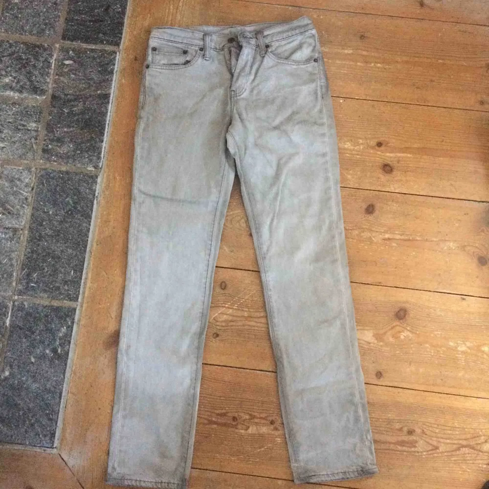 Gråa Levis jeans som är ganska slitna eftersom de är typ missfärgade baktill. . Jeans & Byxor.