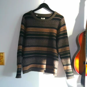  - Stickad tröja med lappar på ärmarna. 