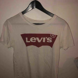  - Vit T-shirt med rött Levi’s tryck  Den är i bra skick 