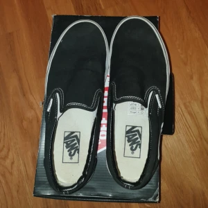  - Klassiska svarta Vans slip-on i strlk EU 40/Men US 7.5/Women US 9. Jättesnygga, passar till allting och går aldrig ur trend. Inte slitna alls då de nästan är oanvända (kanske använda 1-2 ggr utomhus), bara ser lite dammiga ut då de stått i garderoben i sin kartong i flera år men det är lätt att fixa.  Svarar gärna på frågor om varan. :)  Det går bra att pruta!! Priset går att diskutera vid snabb affär.