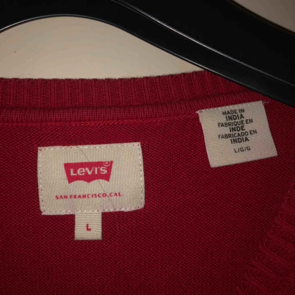 Röd Levi’s tröja köpt från Levi’s affär. Nyskick. Använd endast 2 gånger. Storleken är L men passar S/M. Tröjor & Koftor.