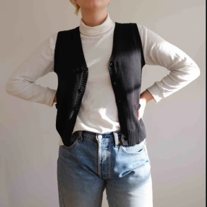  - Svart stickad väst i storlek S. Supersnygg att ha över tröjor eller bara för sig själv! 