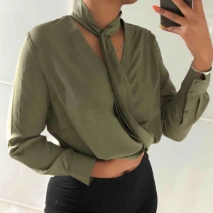  - Militärgrön blus från nakd med knytning runt halsen. Möts i Sthlm köparen står för frakt