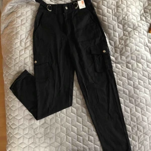  - Säljer dessa mega snygga nya cargo byxorna. Snygga silver detaljer i midjan och på fickorna. Säljer pga köpte fel storlek, köpte dom i London och kan ej lämna tillbaka. Aldrig använda!