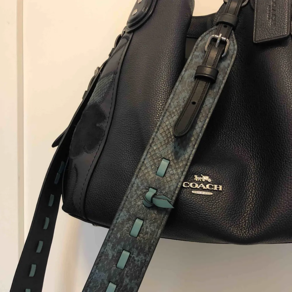 Edie shoulder bag från coach. Knappt använd och i mycket bra skick, säljer p.g.a används ej. Köpt i för 5500 kr inkl. bandet. Säljer för 2600. Stor och liten dustbag kommer med.  Höjd: 27 cm Längd 30 cm. Väskor.