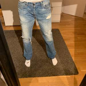 Ett par snygga Abercrombie & Fitch jeans med jeansblå färg och perfekta slitningar. Storlek 33/32.