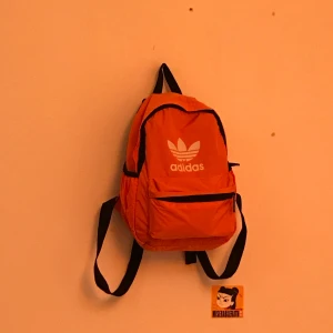 Neon Orange Adidas Mini Ryggsäck - En mini Adidas ryggsäck i neonorange färg. Ingen aning om det är fejk eller äkta. Använd 1 gång och är så gott som ny. Säljer för 90kr + frakt🧡🧡 Priset går att diskuteras.