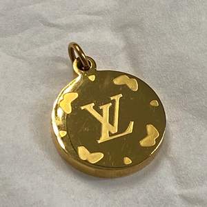 Ett guldfärgat hänge Louis Vuitton att hänga på en kedja AAA-kopia. Diameter 2 cm. Jättefint! Frakt 12:-