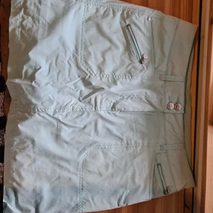 Turkos kjol  - Fin turkos kjol, använd max 5gr. Är något solblek men i överit fint skick. Kjolen har "byxor" som sitter ihop med den under. Kjolen har även fickor. Har swish. Köparen betalar för frakten.