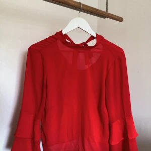 Röd blus  - En jättefin röd blus med vida ärmar samt en öppning på ryggen som man knyter igen till en rosett! ❤️