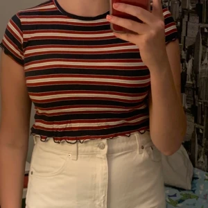 Randig crop top - Randig croppad tröja med ”ruffles” i kanterna. Köpt på Pull & Bear för några år sedan men den har inte kommit till användning eftersom den är lite för liten. Står stl L men jag tycker den sitter som M. 