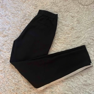  - Kostymbyxor med vita streck längs med benen! 