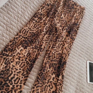 Leobyxor - Plisserade byxor med leoprint. Aldrig använda. Strl 32
