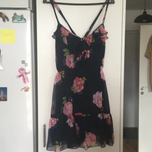 Hollister klänning stl M - Mörkblå klänning med knappar framtill. Perfekt att ha på sommaren. Kors i ryggen av axelbanden fastsydd mörkblå underklänning. 