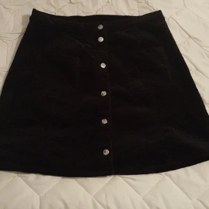 Manchester kjol - Ginatricot stl S - Manchester kjol från Ginatricot, modellen är "A-line".. Aldrig använd då den tyvärr är för stor. Har två fickor fram och knäppning med knappar hela vägen ner!