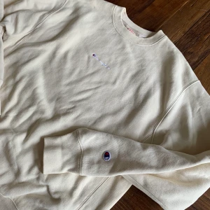 Champion Crewneck  - Jättefin Champion Crewneck i en ljus beige/vit krämig färg, har aldrig kommit till användning och är i super bra skick. 400kr ink frakt 