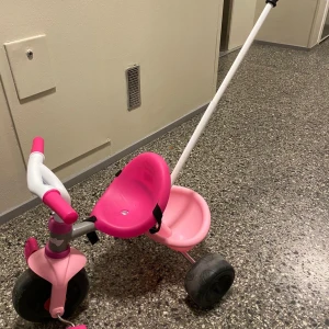 En röd cykel med extra stöd hjul - Perfekt för 2 åring att börja lära sig cykla , det är ingen fel på cykel. Min dotter använda några gånger , hon hann växa ur den.