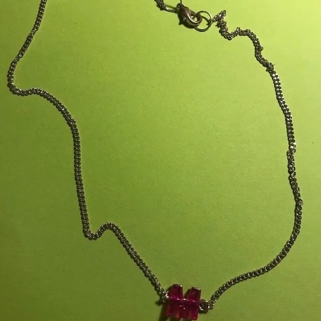 Halsbands kedja silver, med ett lila/rosa M. . Accessoarer.