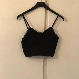 Bralette/topp - En superfin crop top/bralette i svart spets från New Look! Säljer då den tyvärr har blivit för liten. Superfin och perfekt med ett par högmidjade byxor och en kofta! Skriv för fler bilder. Priset kan diskuteras! :-)