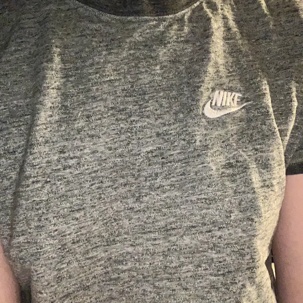 Grå T-shirt från Nike. Har mörkare grå kant runt hals och armar. Köpt second hand men inga skavanker.. Skjortor.