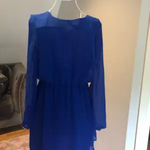 Klänningen är aldrig använd. Blå klänning med öppen rygg och fint guldsmycke baktill. Från bikbok.