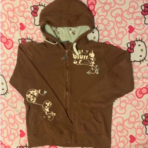 Brun hoodie med tryck - Så fin brun oversize hoodie med ljusa tryck som är perfekt oversize på mig som har storlek 34-36. Storlek L men passar XS-XL beroende hur man vill att den ska sitta. Köpt på Depop. Detaljerna gör denna hoodien så unik och ger den något extra💕Högsta bud: 280kr+frakt