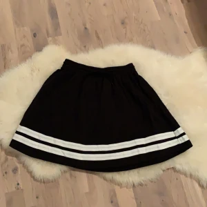 Svart kjol från Esteadeur - Svart kjol med vita ränder i storlek S. Materialet är av bomull. Aldrig använd 🖤🤍🖤