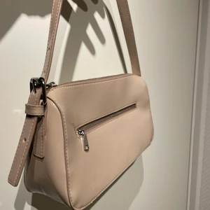 Beige baguette väska  - Fin glansig baguette väska i beige färg från h&m. Använd typ 2 ggr så i väldigt bra kvalitet. 40kr i frakt 