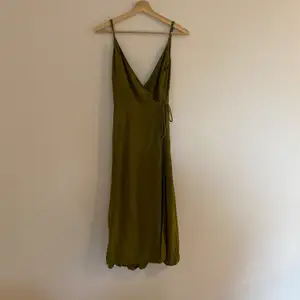 V-ringad olivgrön klänning. Längd- under knät. Storlek 36. 120kr + frakt. 