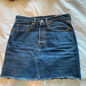 Levi’s högmidjad jeankjol - Helt ny kjol som knappt är använd. Den är väldigt hög i midjan och har knappknäppning hela vägen upp. Budgivning börjar på 300kr.