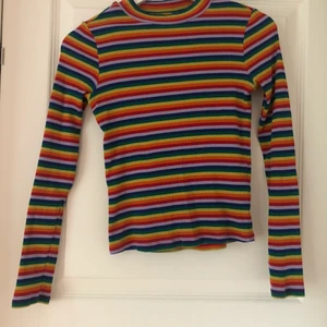 Regnbågsfärgad tröja från Monki - Säljer den då jag växte ur den o den blev för kort i ärmarna Har låg turtleneck, har använts mycket men i fint skick