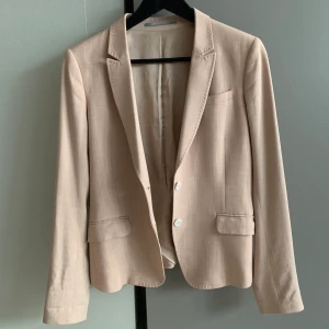 Tiger of Sweden kavaj dam i stl 38 i ull - Fantastisk fin och klassisk kavaj från Tiger of Sweden. I storlek 38. Ljus rosa något mot aprikos. 60% viscose och 37% wool och 3% elastan. Nypris 3500kr.