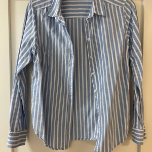 Skjorta  - En blå/vit skjorta i fint skick.