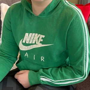 Nike Hoodie strl S - Grön Hoodie från nike. Stilrena linjer som löper längs hela armarna och över luvan. Tycket är något slitet men enligt min mening är det bara ett stort plus då det bara ser retro ut. 