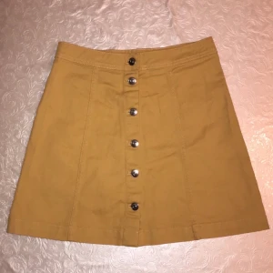 Knappkjol - En fin gul knapp kjol från H&M. Har aldrig använt då den sitter lite löst i midjan och ej är justerbar. Kan användas till sommaren eller redan nu till jul. Köpare står för frakt. Köptes för 175:) storlek 36 = S